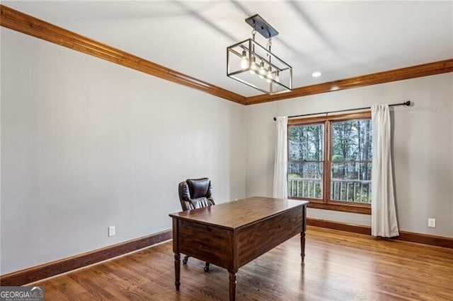 home office with hardwood / wood-style flooring, ornamental molding, and a chandelier