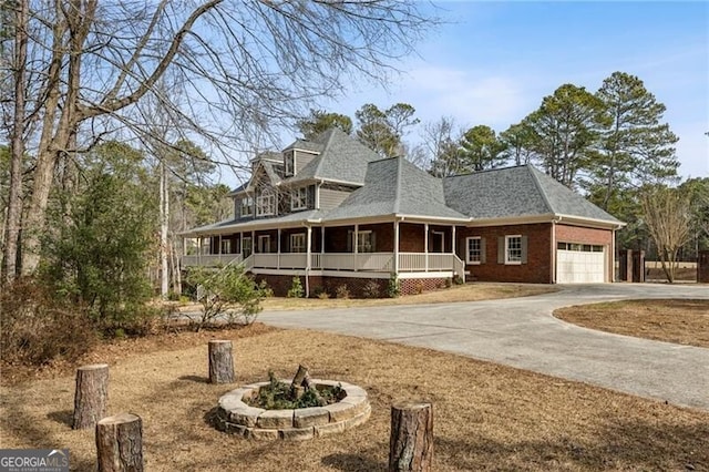 country-style home featuring a garage and covered porch