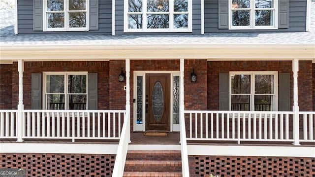 view of exterior entry with a porch