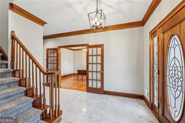 foyer entrance featuring a notable chandelier, ornamental molding, and french doors