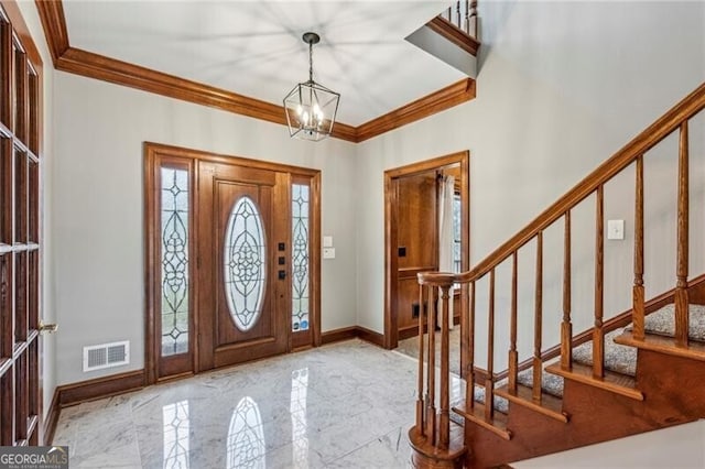 foyer with an inviting chandelier and crown molding