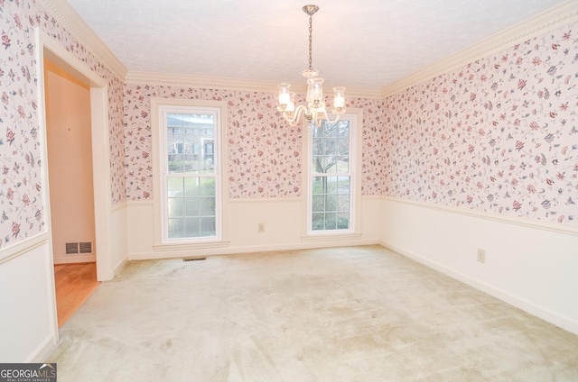 carpeted empty room with crown molding, a textured ceiling, and a chandelier