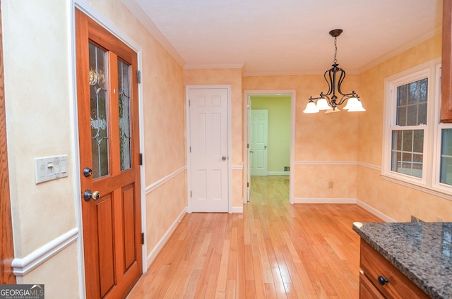 dining room with a notable chandelier, light hardwood / wood-style flooring, and ornamental molding