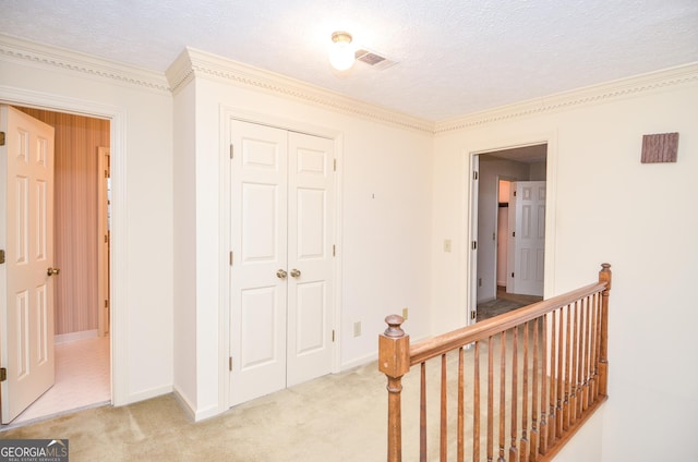 corridor featuring light carpet and a textured ceiling