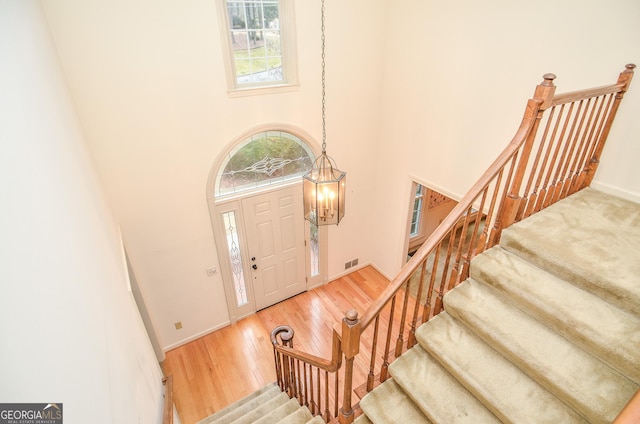 foyer with a chandelier, hardwood / wood-style floors, and a high ceiling