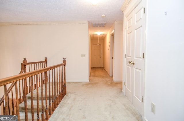 corridor featuring light carpet and a textured ceiling