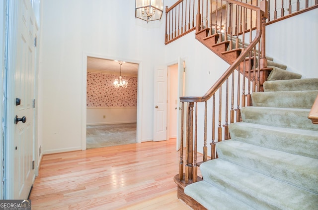 entrance foyer featuring hardwood / wood-style flooring, a high ceiling, and a notable chandelier