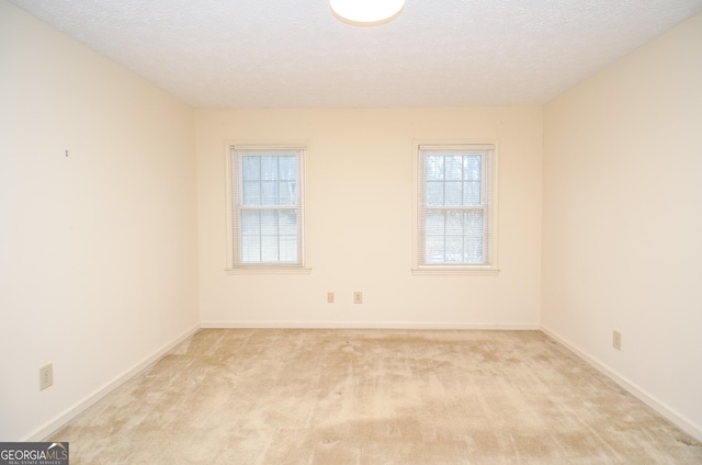 carpeted spare room featuring a textured ceiling