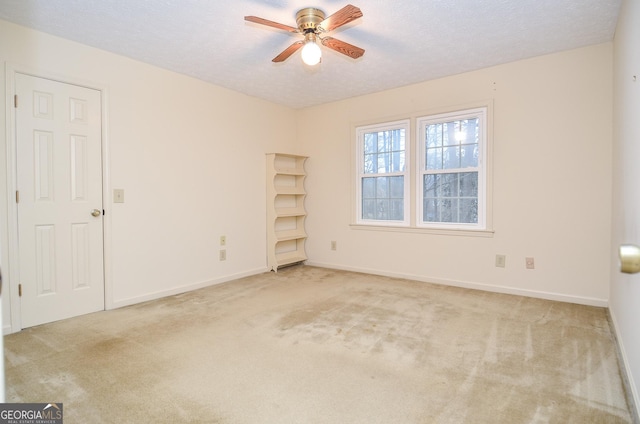 carpeted empty room with ceiling fan and a textured ceiling