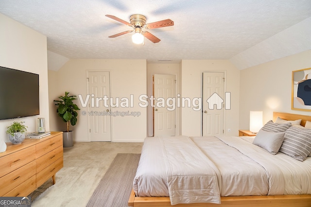 bedroom featuring vaulted ceiling, light colored carpet, ceiling fan, and a textured ceiling