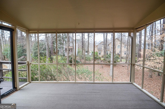 unfurnished sunroom featuring vaulted ceiling