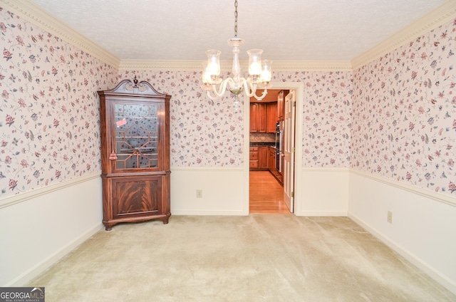 unfurnished dining area featuring ornamental molding, light colored carpet, and an inviting chandelier