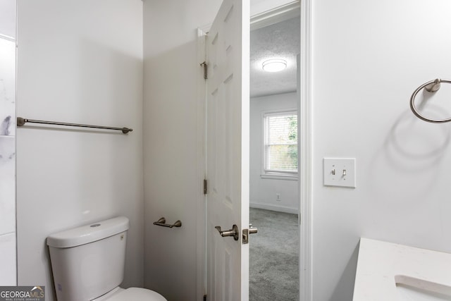 bathroom with toilet and a textured ceiling