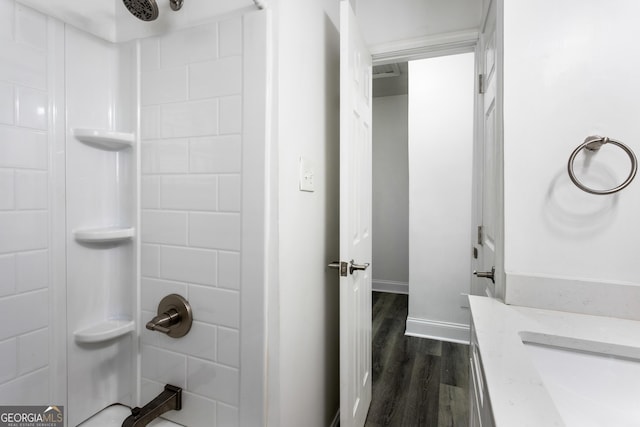 bathroom with baseboards, walk in shower, and wood finished floors