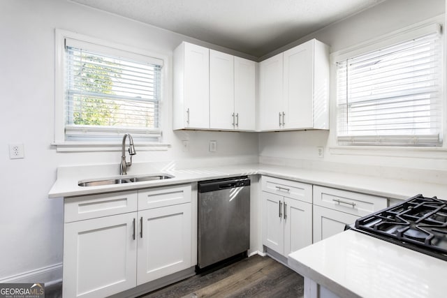 kitchen with dark wood-style flooring, a sink, white cabinets, light countertops, and stainless steel dishwasher