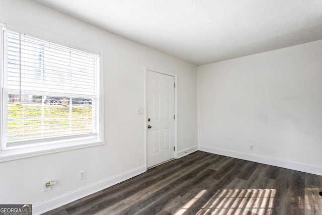 foyer with dark wood finished floors and baseboards