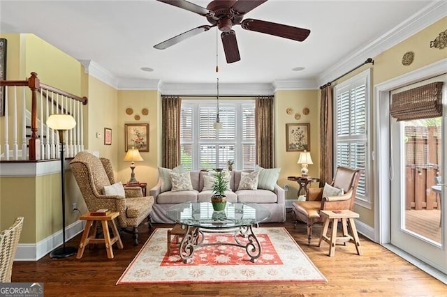 living room featuring crown molding, light hardwood / wood-style flooring, and ceiling fan