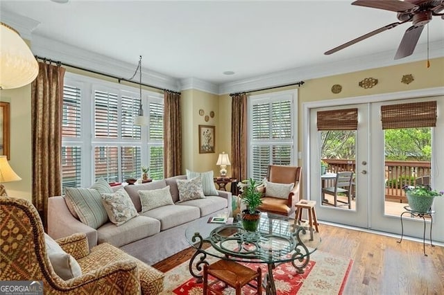 living room featuring light hardwood / wood-style floors, ornamental molding, french doors, and ceiling fan