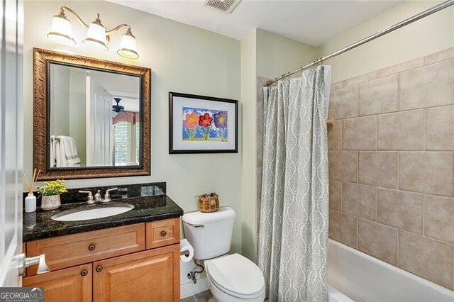 full bathroom featuring vanity, shower / tub combo, and toilet