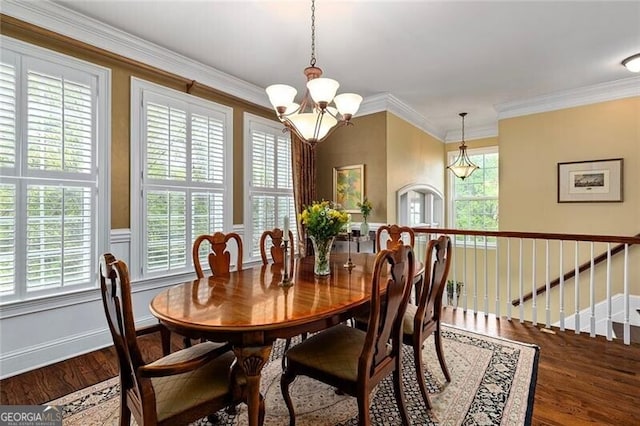 dining space with an inviting chandelier, ornamental molding, and hardwood / wood-style floors