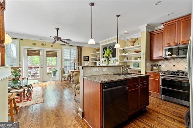 kitchen with sink, dark stone counters, hanging light fixtures, stainless steel appliances, and french doors