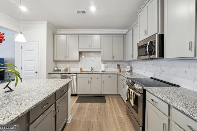 kitchen with sink, crown molding, appliances with stainless steel finishes, gray cabinetry, and decorative light fixtures