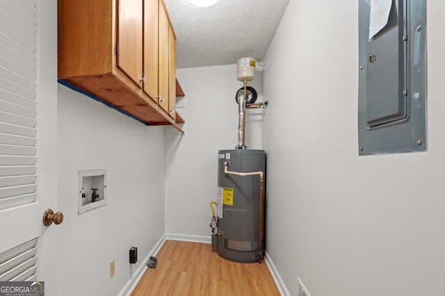 laundry room with water heater, electric panel, cabinets, washer hookup, and a textured ceiling