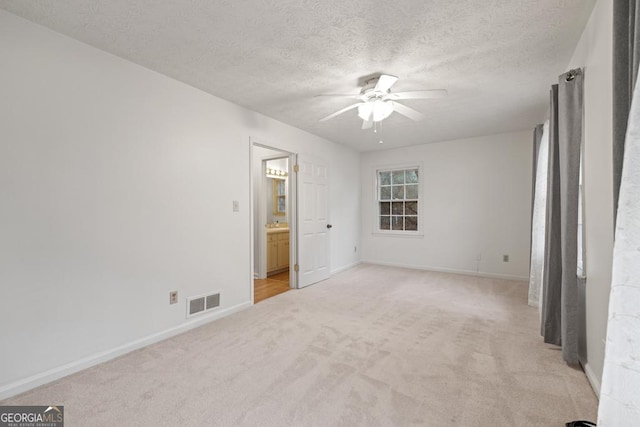 carpeted spare room with ceiling fan and a textured ceiling