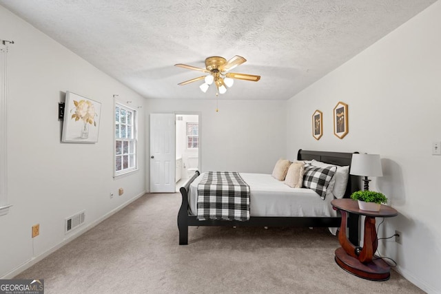 carpeted bedroom with ceiling fan and a textured ceiling