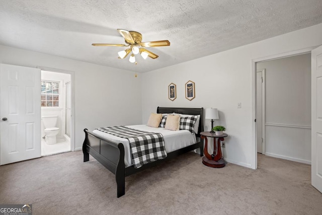 carpeted bedroom featuring ensuite bathroom, ceiling fan, and a textured ceiling