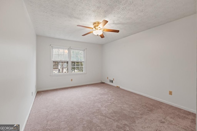 carpeted spare room with a textured ceiling and ceiling fan