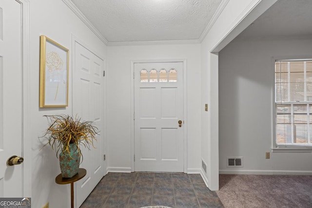 carpeted foyer entrance featuring crown molding and a textured ceiling