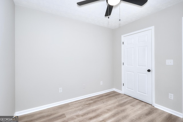 spare room with ceiling fan, a textured ceiling, and light hardwood / wood-style flooring