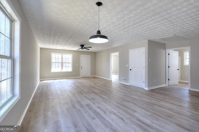 spare room with a textured ceiling, light hardwood / wood-style flooring, and ceiling fan