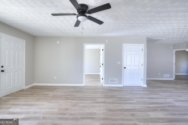 unfurnished room with ceiling fan, light hardwood / wood-style flooring, and a textured ceiling