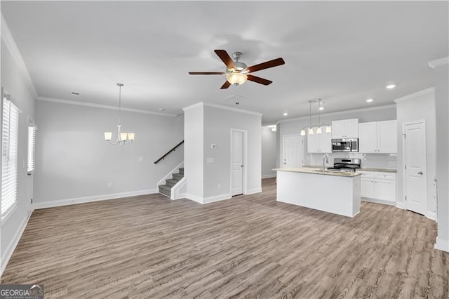 kitchen featuring a kitchen island with sink, decorative light fixtures, white cabinets, and appliances with stainless steel finishes