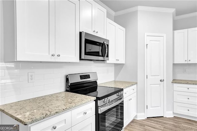 kitchen featuring appliances with stainless steel finishes, backsplash, white cabinets, and light stone counters