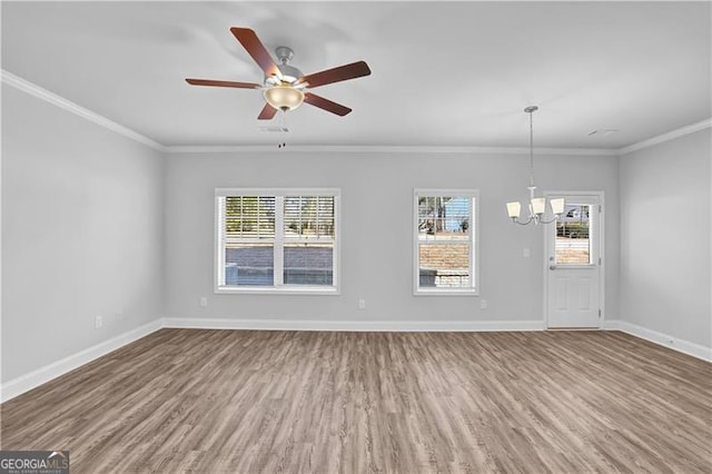 spare room with hardwood / wood-style floors, crown molding, and ceiling fan with notable chandelier