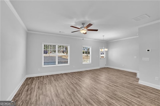 empty room with hardwood / wood-style floors, ceiling fan with notable chandelier, and ornamental molding