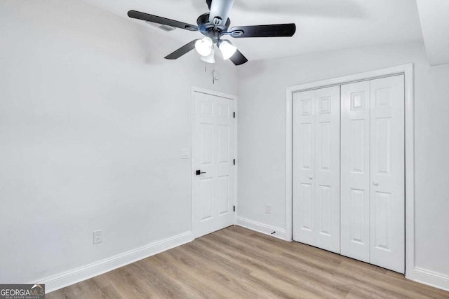 unfurnished bedroom with light hardwood / wood-style floors, a closet, and ceiling fan