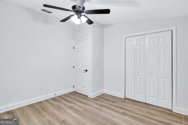 unfurnished bedroom with ceiling fan, light hardwood / wood-style floors, and a closet