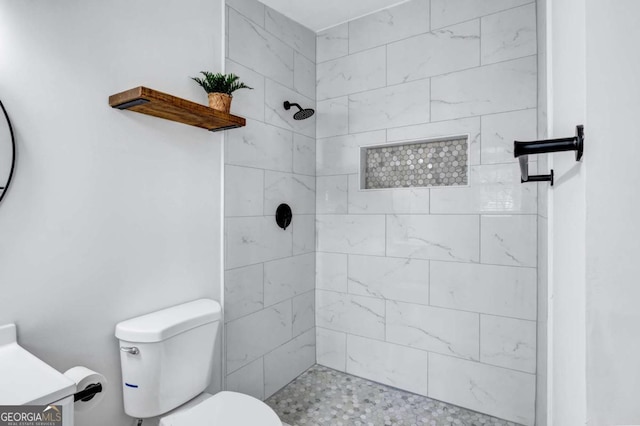 bathroom with vanity, a tile shower, and toilet