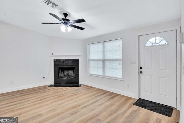 entrance foyer with a fireplace, light hardwood / wood-style floors, and ceiling fan