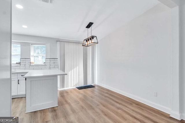 unfurnished dining area featuring light wood-type flooring