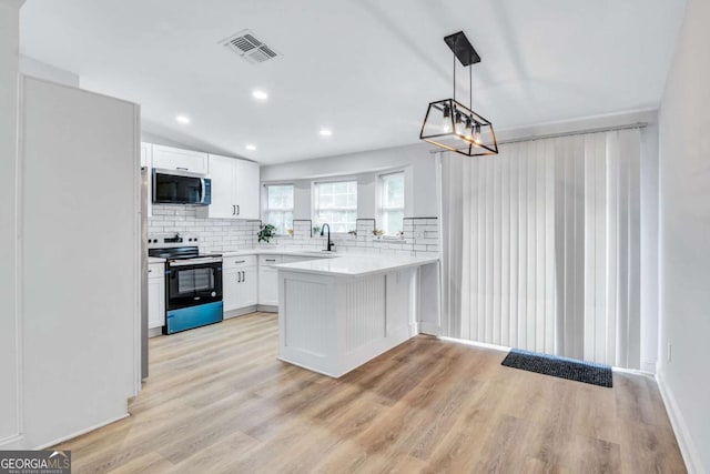 kitchen with kitchen peninsula, white cabinets, pendant lighting, stainless steel appliances, and backsplash