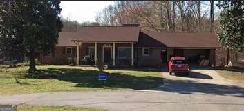 view of front facade featuring aphalt driveway and a front yard