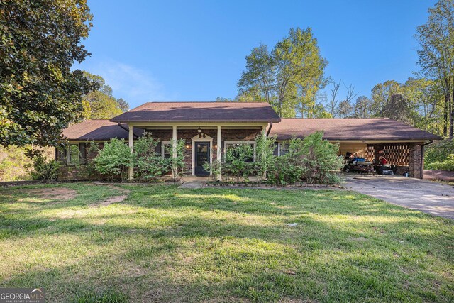 ranch-style home featuring concrete driveway, a front yard, and an attached carport