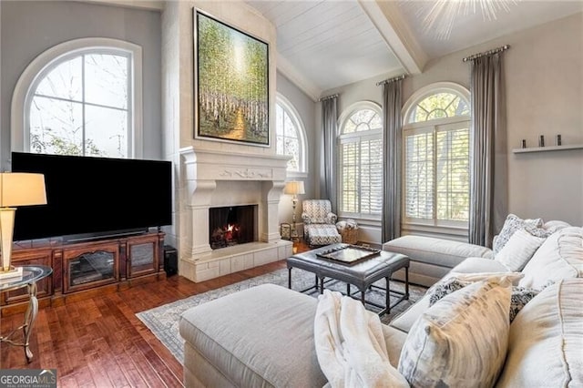 living room featuring beam ceiling, dark hardwood / wood-style floors, and a healthy amount of sunlight