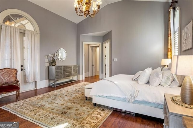 bedroom featuring lofted ceiling, dark hardwood / wood-style flooring, and a chandelier