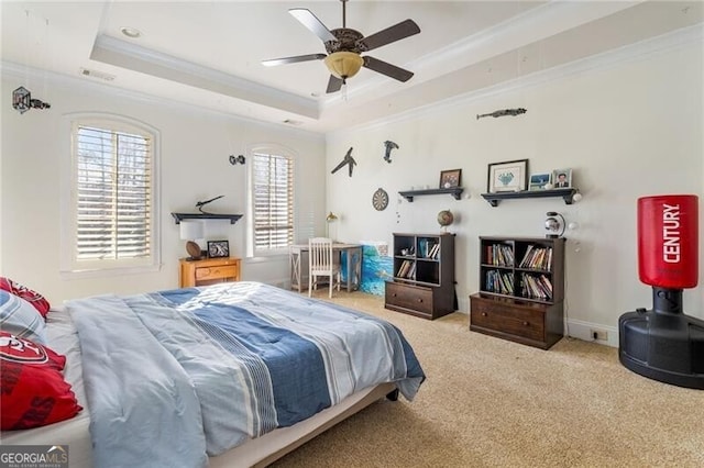 bedroom with crown molding, ceiling fan, a tray ceiling, and carpet floors